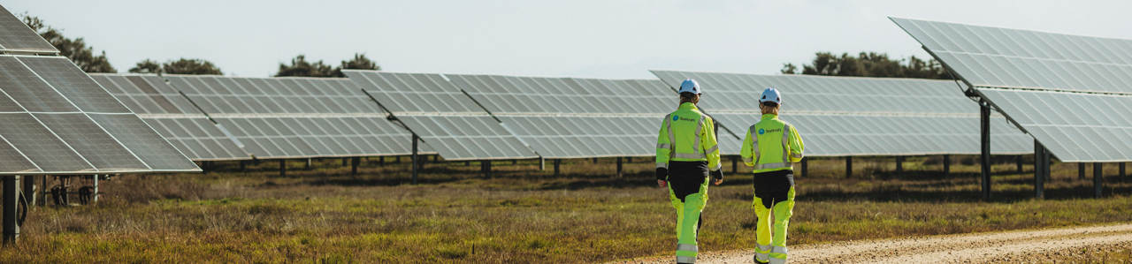 Due tecnici Statkraft che camminano nei pannelli fotovoltaici